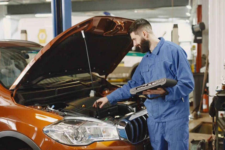 Mechanic checking a car engine with diagnostic equipment